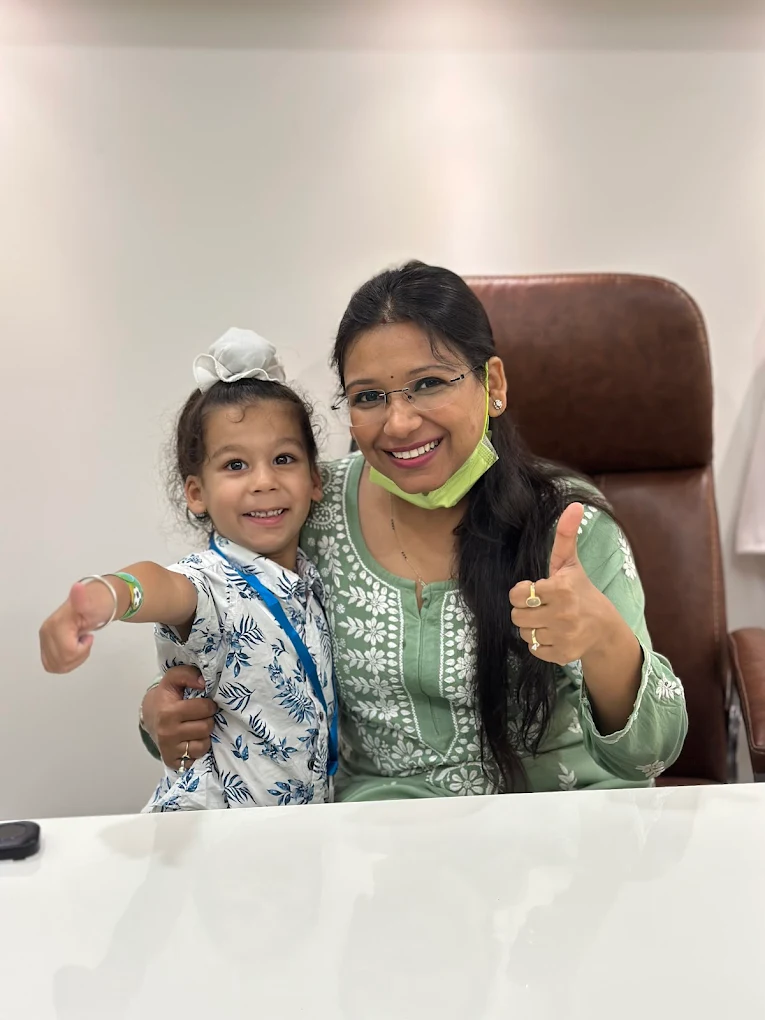 Dr. Anukriti Gupta with a young patient giving a thumbs up